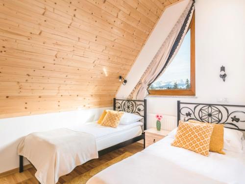 2 camas en una habitación con ventana en Anielska Osada, en Groń
