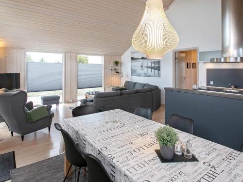 a living room with a table with chairs and a couch at 6 person holiday home in V ggerl se in Bøtø By