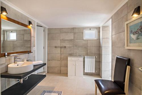 a bathroom with a sink and a chair in it at Apartment Mel de Flor in Loulé