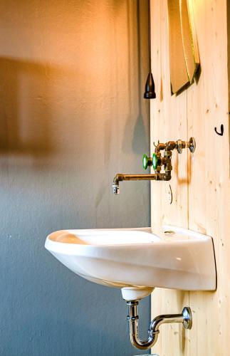 a white sink attached to a wooden wall at The Keep Eco Rooms in Salzburg