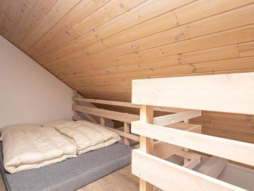 a bed in a room with a wooden ceiling at Grand holiday home- Type 11 in Blåvand
