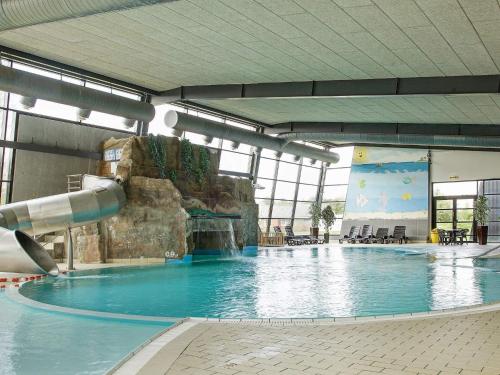 a large swimming pool with a water slide at Grand holiday home- Type 11 in Blåvand