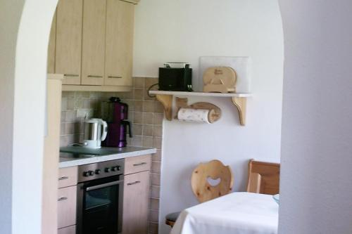 una pequeña cocina con fogones y mesa. en Haus Fichteneck en Berchtesgaden
