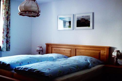 um quarto com uma cama e duas fotografias na parede em Haus Fichteneck em Berchtesgaden