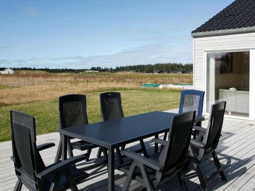una mesa negra y sillas en una terraza en 10 person holiday home in Brovst, en Brovst