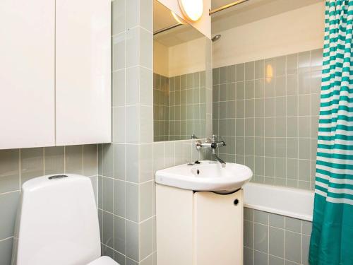 a bathroom with a sink and a toilet and a mirror at 6 person holiday home on a holiday park in Faaborg in Fåborg