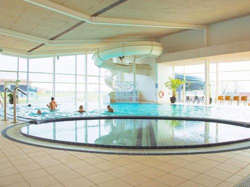 ein Pool in einem Hotel mit Menschen im Wasser in der Unterkunft 6 person holiday home on a holiday park in Gråsten in Gråsten