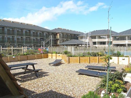 a courtyard with benches in front of a building at 6 person holiday home on a holiday park in Fanø in Fanø