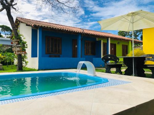 una piscina frente a una casa en Casas Aconchegantes Temporada, en Cabo Frío