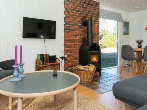 a living room with a fireplace and a coffee table at 5 person holiday home in Glesborg in Glesborg
