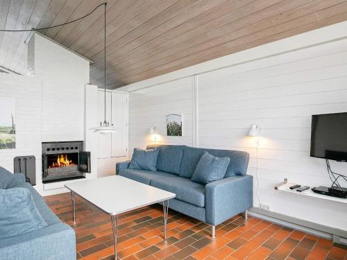 a living room with a couch and a fireplace at Vigsø Holiday Center- Type 7 in Hanstholm