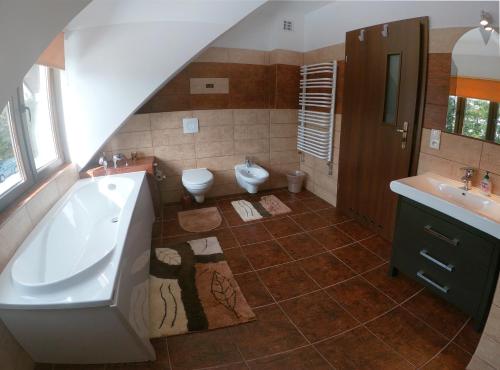 a bathroom with a tub and a toilet and a sink at Bereszczańskie Sioło in Berezka