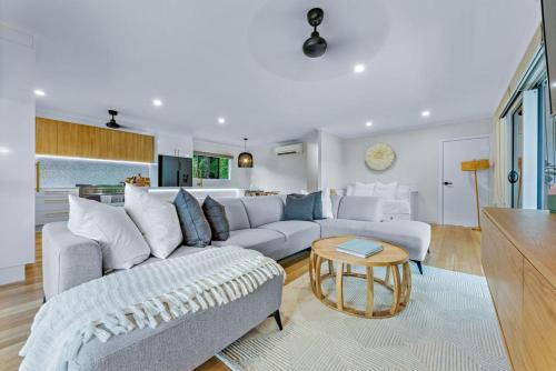 a living room with a couch and a table at Airlie Abode in Airlie Beach