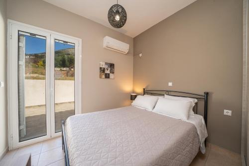 a bedroom with a bed and a large window at Seaside Euphoria Kefalonia in Ayia Evfimia