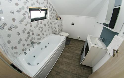 a bathroom with a tub and a toilet and a sink at apart bun in Oradea
