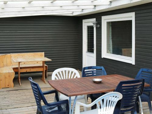 einen Holztisch und Stühle auf einer Terrasse in der Unterkunft 6 person holiday home in Hadsund in Nørre Hurup