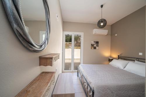 a bedroom with a bed and a mirror on the wall at Seaside Euphoria Kefalonia in Ayia Evfimia