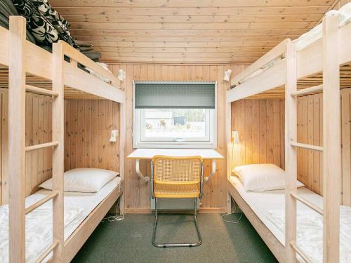 een kamer met 2 stapelbedden en een stoel. bij Three-Bedroom Holiday home in Blokhus 4 in Blokhus
