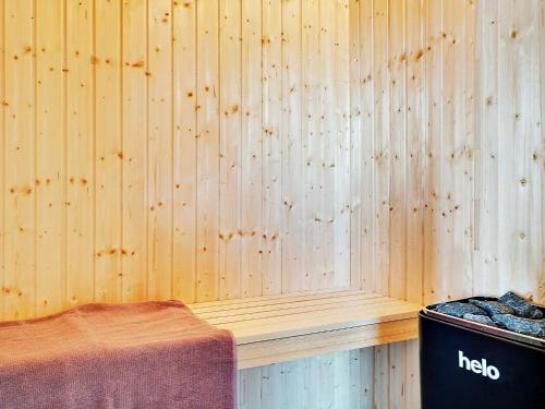 a room with a wooden wall with a trash can at 24 person holiday home in Grenaa in Grenå