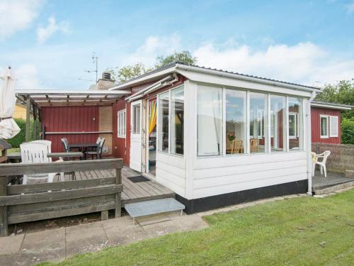 une véranda couverte d'une maison rouge avec une terrasse dans l'établissement 4 person holiday home in Haderslev, à Haderslev