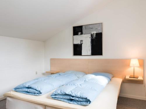Un dormitorio con una cama con almohadas azules. en Holiday home Blåvand CXCV, en Blåvand