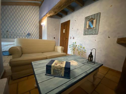 a living room with a couch and a table with a book at Posada Restaurante Fuenteplateada in Collado Hermoso