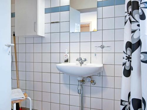 y baño con lavabo y espejo. en Holiday Home Brøddegade III, en Gudhjem
