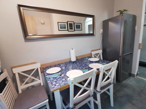 een keuken met een tafel met stoelen en een koelkast bij Smart Szállás apartman in Miskolc in Miskolc