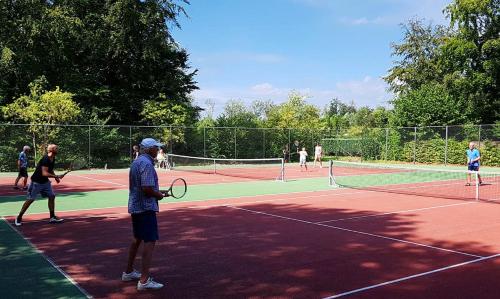 a group of people playing tennis on a tennis court at Bungalowpark De Bremerberg in Biddinghuizen