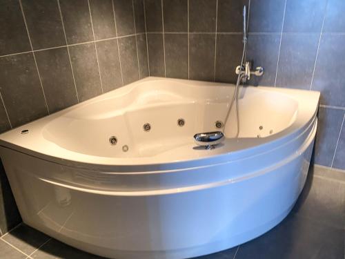 a white bath tub in a tiled bathroom at Hello Zeeland - Appartement Port Scaldis 01-001 in Breskens