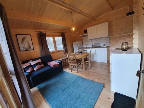 a living room with a couch and a kitchen at Domki Letniskowe w Burdągu in Jedwabno