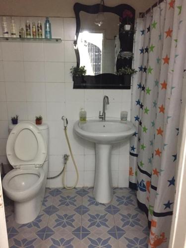 a bathroom with a toilet and a sink at Chez Eva Jolie in Dakar