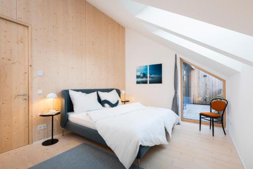 a bedroom with a bed and a window at HIMMELBLAU - Design Apartment am Mondsee in Mondsee