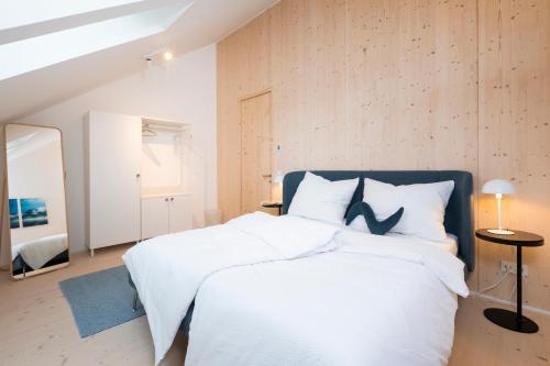 a bedroom with a large white bed with white pillows at HIMMELBLAU - Design Apartment am Mondsee in Mondsee