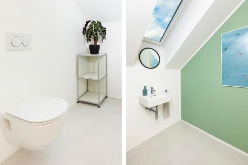 een badkamer met een dakraam, een toilet en een wastafel bij HIMMELBLAU - Design Apartment am Mondsee in Mondsee
