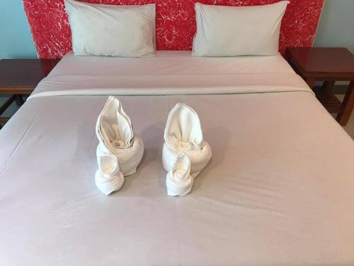a pair of white shoes sitting on a bed at PTK BEACH in Chaweng