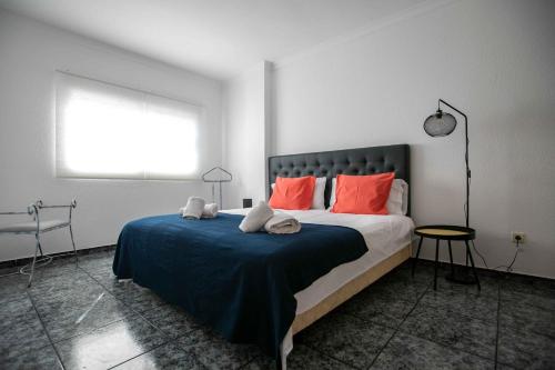 ein Schlafzimmer mit einem großen Bett mit orangefarbenen Kissen in der Unterkunft La Buena Vida, by Comfortable Luxury in Corralejo