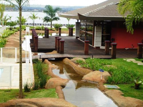 a building with a walkway next to a river at Flat à Beira Lago in Brasilia