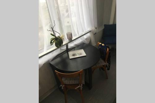 a table and chairs in a room with a window at Studio 24 - Coucher de Soleil & Vue Mer in Courseulles-sur-Mer