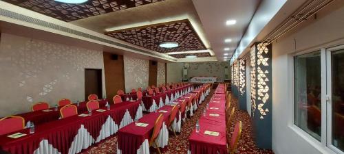 a banquet hall with red and white tables and chairs at Lee-Benz ARK HOTEL in Kumbakonam