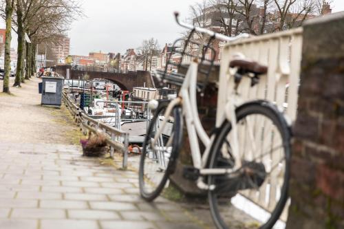 a bike parked next to a wall next to a canal at Wellnessboat De Michiel de Ruyter in Groningen