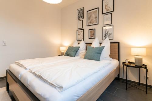 1 dormitorio con 1 cama blanca grande y 2 lámparas en Ankerplatz, en Tönning
