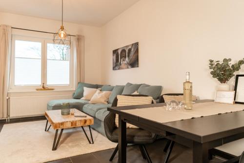 uma sala de estar com um sofá azul e uma mesa em Ankerplatz em Tönning