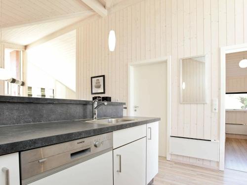 a kitchen with white cabinets and a sink at Four-Bedroom Holiday home in Großenbrode 1 in Großenbrode