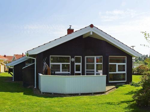 ein kleines schwarzes Haus mit einem großen Fenster in der Unterkunft 6 person holiday home in Otterndorf in Otterndorf