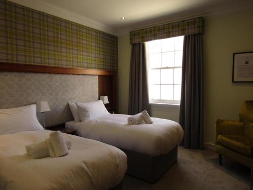a hotel room with two beds and a window at The Craigie Hotel in Penicuik