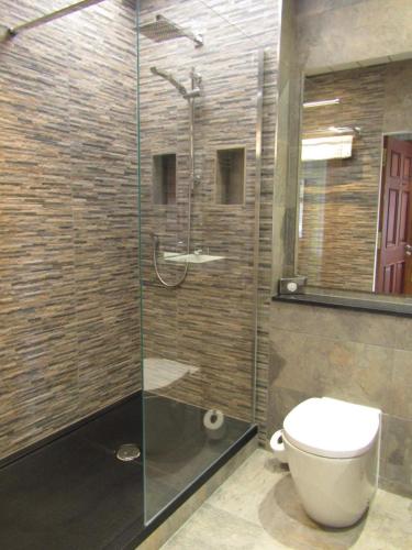 a bathroom with a toilet and a glass shower at The Craigie Hotel in Penicuik