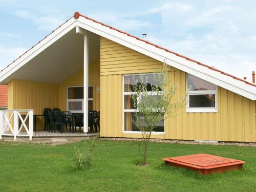 a yellow house with a table in front of it at 12 person holiday home in Otterndorf in Otterndorf