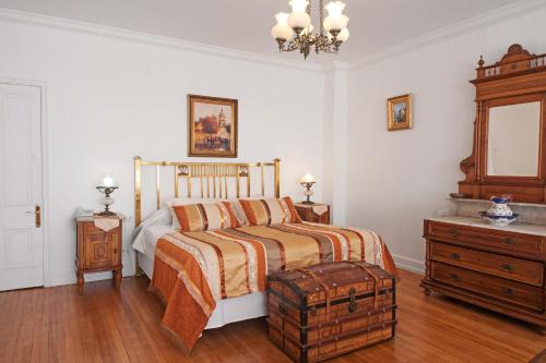 a bedroom with a bed and a wooden dresser at Hotel Casa Somerscales in Valparaíso