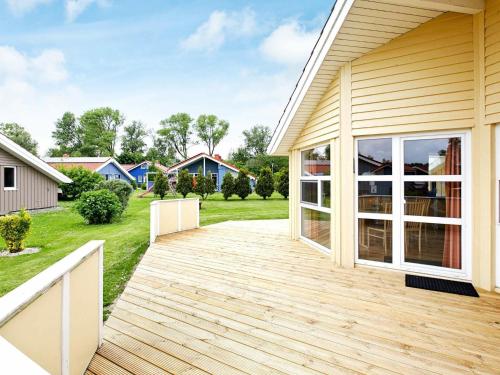 una terraza de madera en el lateral de una casa en 4 person holiday home in Otterndorf en Otterndorf